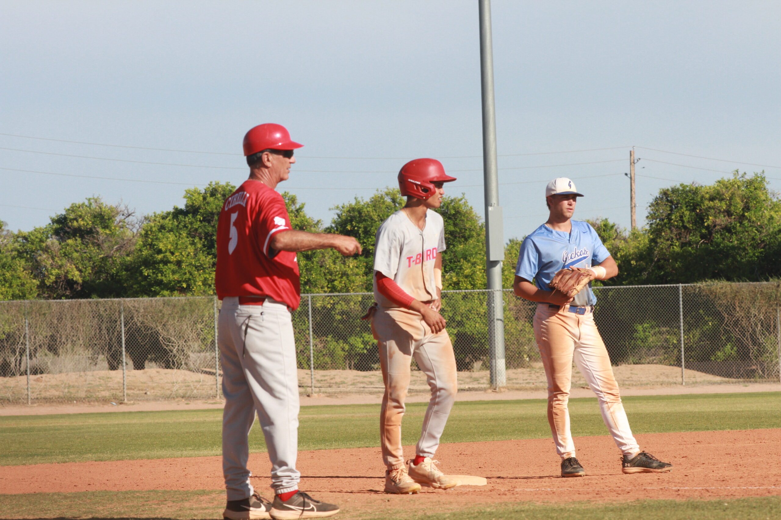 Head coach Tony Cirelli (left) coaching sophomore infielder Jayden Israel (middle) as sophomore utility player for Gateway Community College Jeffrey Martz (right) defends in a game at Gene Autry Park in Mesa, Arizona on April 24, 2024. (Photo by Adam Terro/ The Mesa Legend)