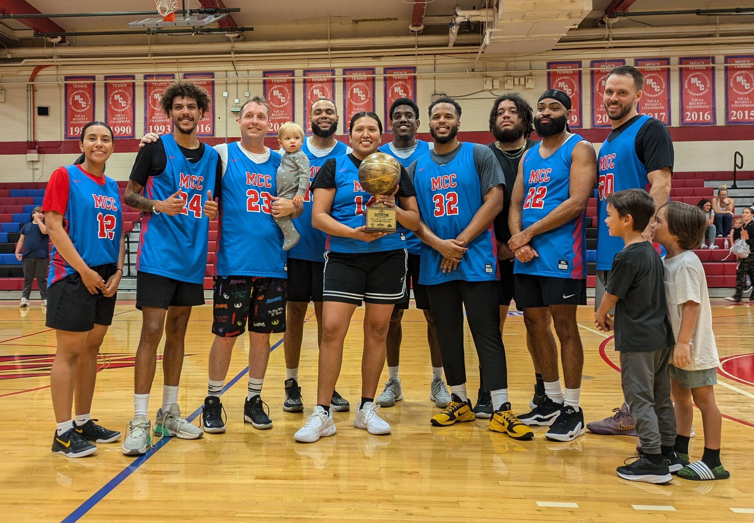 MCC alumni pose for a picture with their trophy after winning the basketball game against law enforcement during the Mesa Basketball Benefit at Mesa Community College's Southern and Dobson Campus on October 11, 2024. (Photo by Riley Weathersbee/The Mesa Legend)