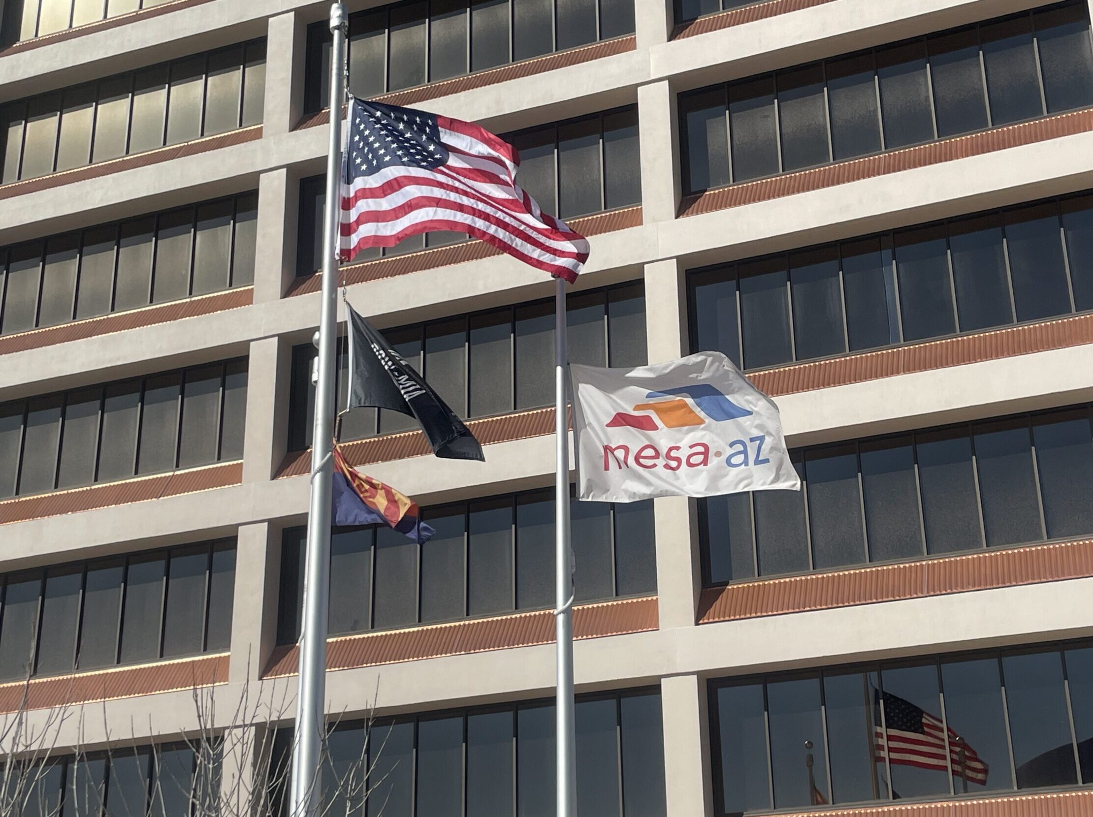 Raised flags waving in front of Mesa City Hall