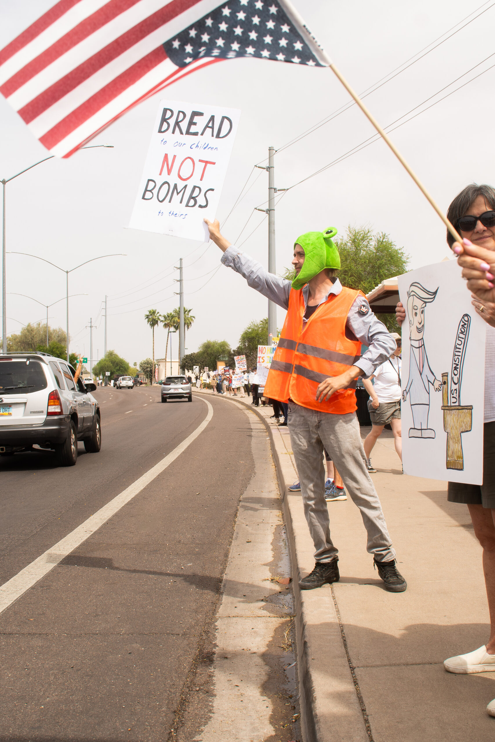 A man holding a sign that reads 'bread to our children, not bombs to theirs' on March 28, 2026 in front of a half-mile line of protesters.
